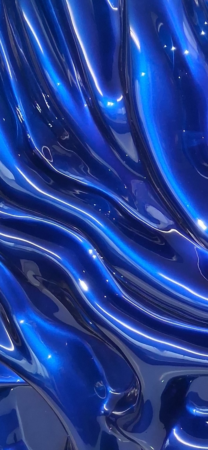 Close-up of a Wacky Walls sculptural surface in deep cobalt blue automotive finish, showing flowing forms and mirror-like gloss